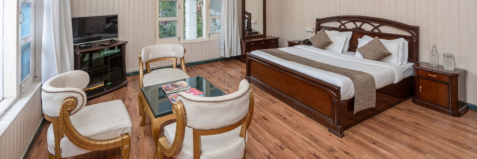 Spacious and bright guest room at DLS Tehri Club Resort with a king size bed and a seating area.